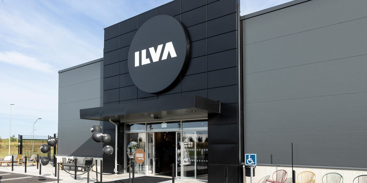 ILVA-butikens fasad med stor rund logotyp ovanför entrén, ballonger och skyltning för grand opening.