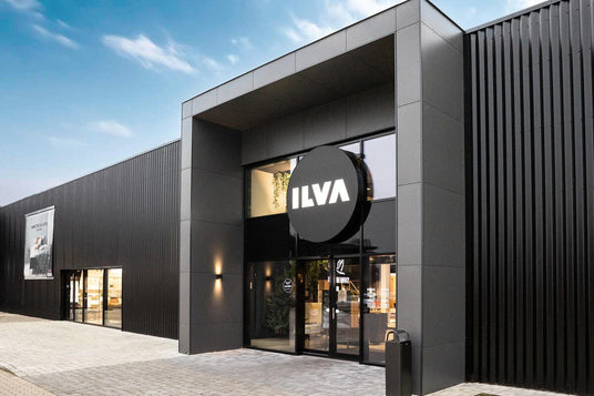 Modern svart butiksfasad med stor rund ILVA‑skylt över glasentrén en ljus dag.