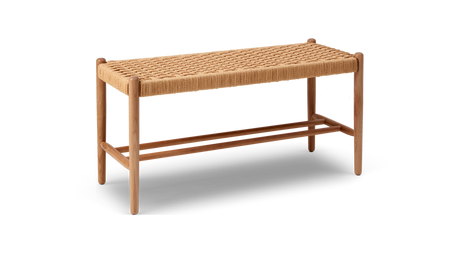 Bänk i ek med flätad sits av naturfärgat snöre, avlång och minimalistisk på vit bakgrund.