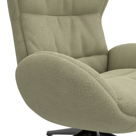 Närbild av en modern loungefåtölj i salviagrönt tyg med mjuk, välvd arm och tuftad sits på svart snurrfot.