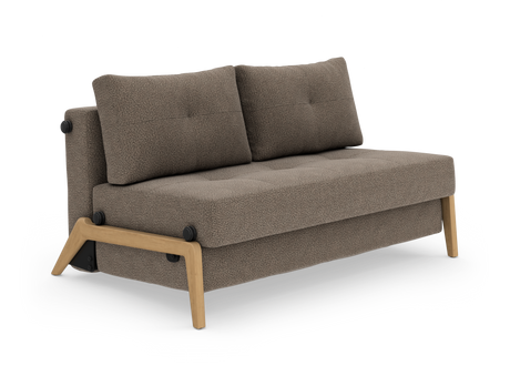 Kompakt tvåsitssoffa i beige/brun textil med träram och ben, två ryggkuddar och tuftad sits, fotograferad i studiomiljö snett framifrån.