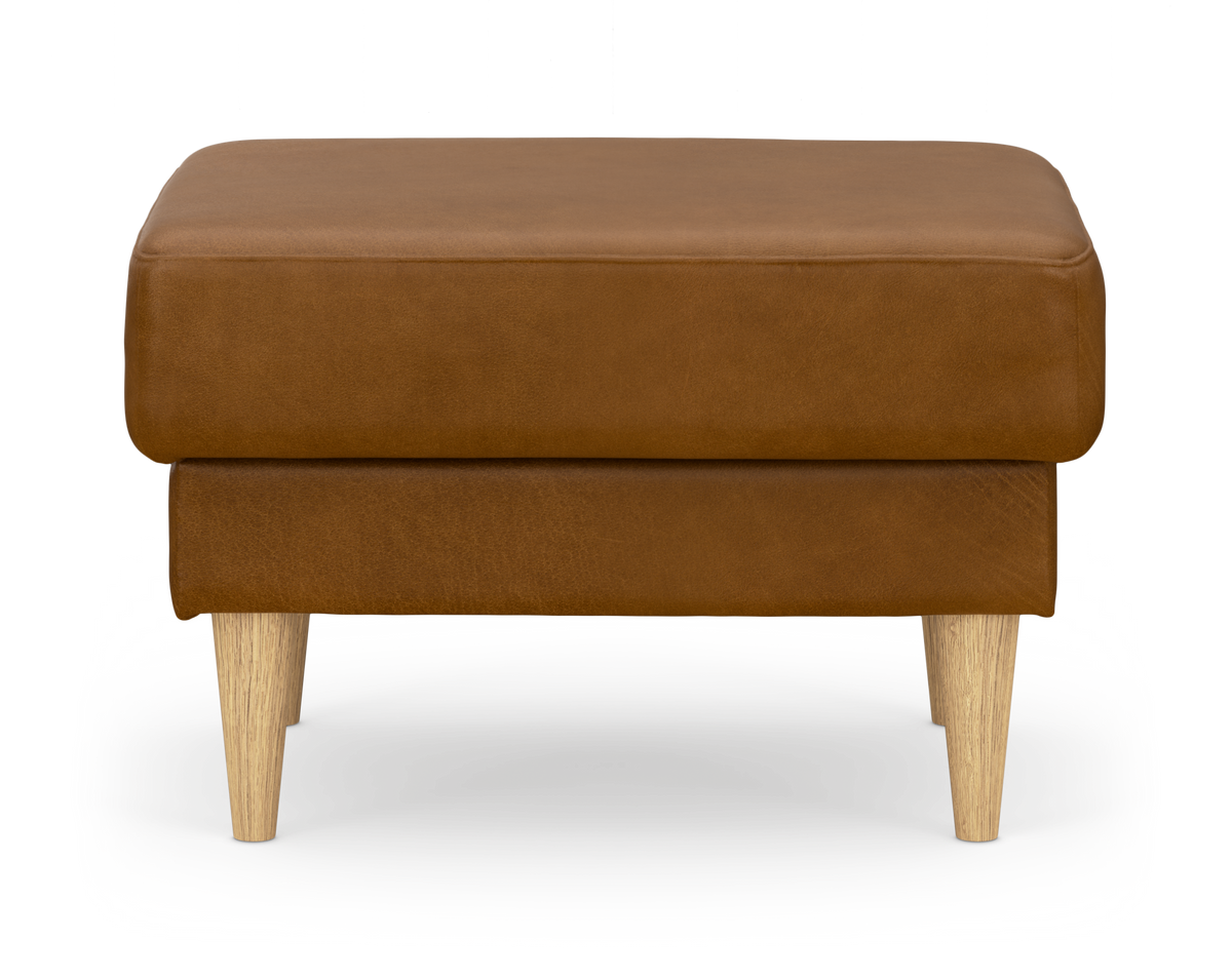 Brun läderpall/ottoman med ljusa träben, fotad rakt framifrån på vit bakgrund.