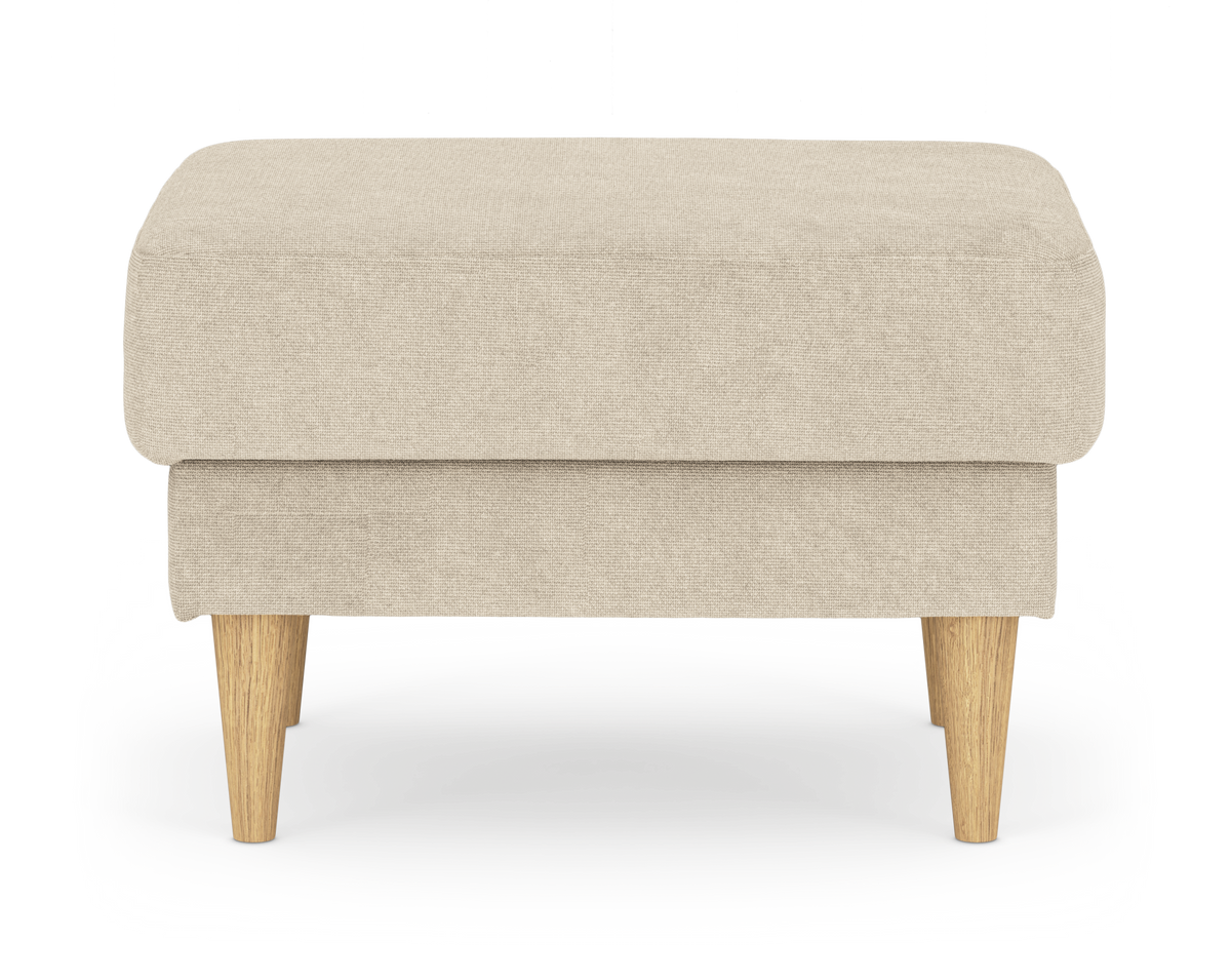 Beige fotpall i tyg med koniska ben i ljust trä, frilagd mot vit bakgrund.