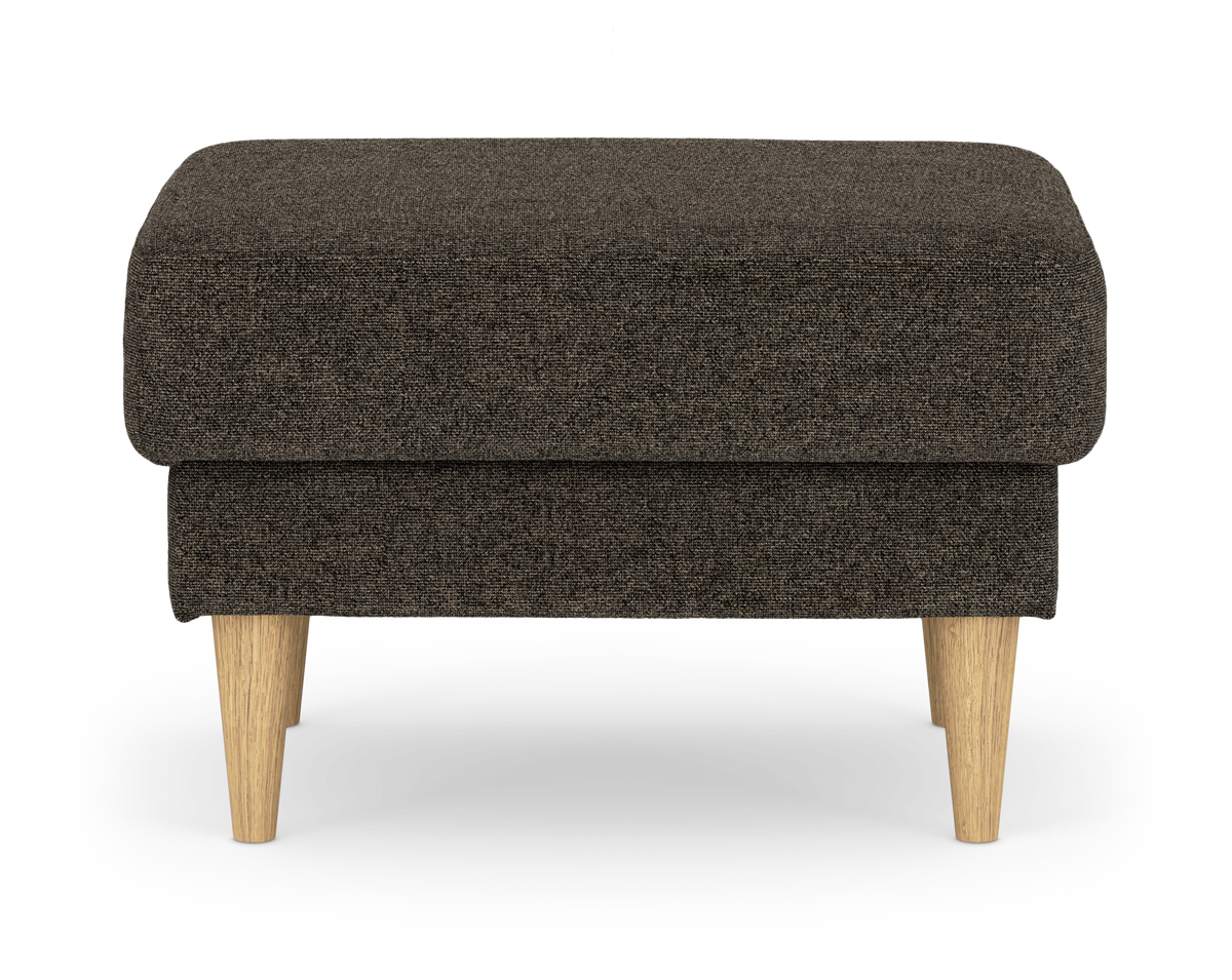Mörkbrun tygpuff/ottoman med ljusa träben, frilagd mot vit bakgrund, sedd framifrån.