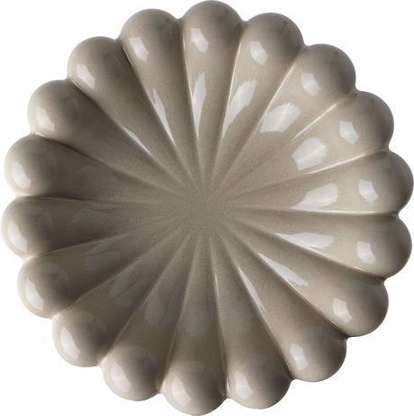 Beige keramikfat med vågig kant, fotograferat uppifrån.