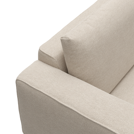 Närbild på beige tygsoffa med armstöd och ryggkudde.