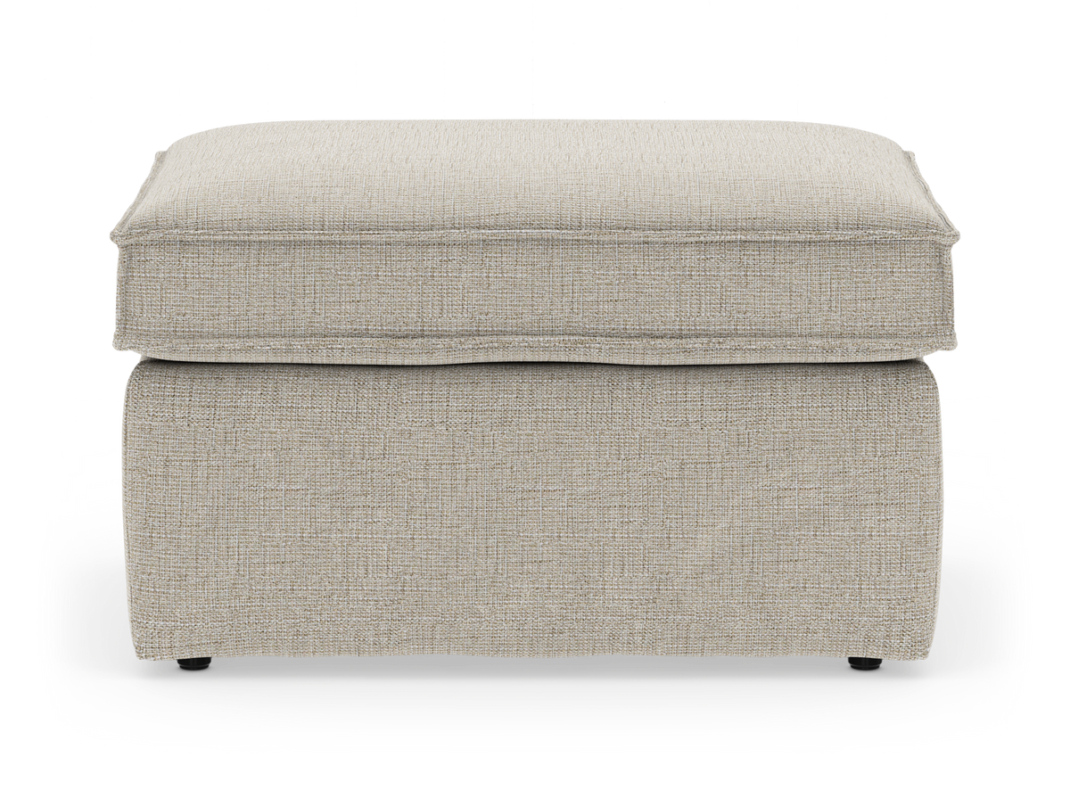 Beige tygklädd ottoman/fotpall med mjuk kuddtopp, frilagd mot vit bakgrund.