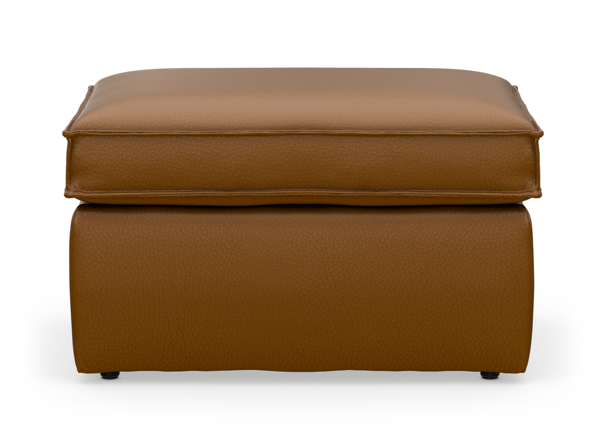 Brun läderpall/ottoman med mjuk sittkudde, frilagd mot vit bakgrund.