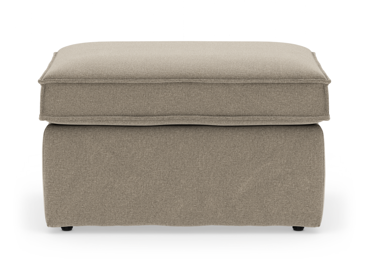 Beige tygklädd ottoman/puff med mjuk kuddtopp sedd framifrån, frilagd på vit bakgrund.
