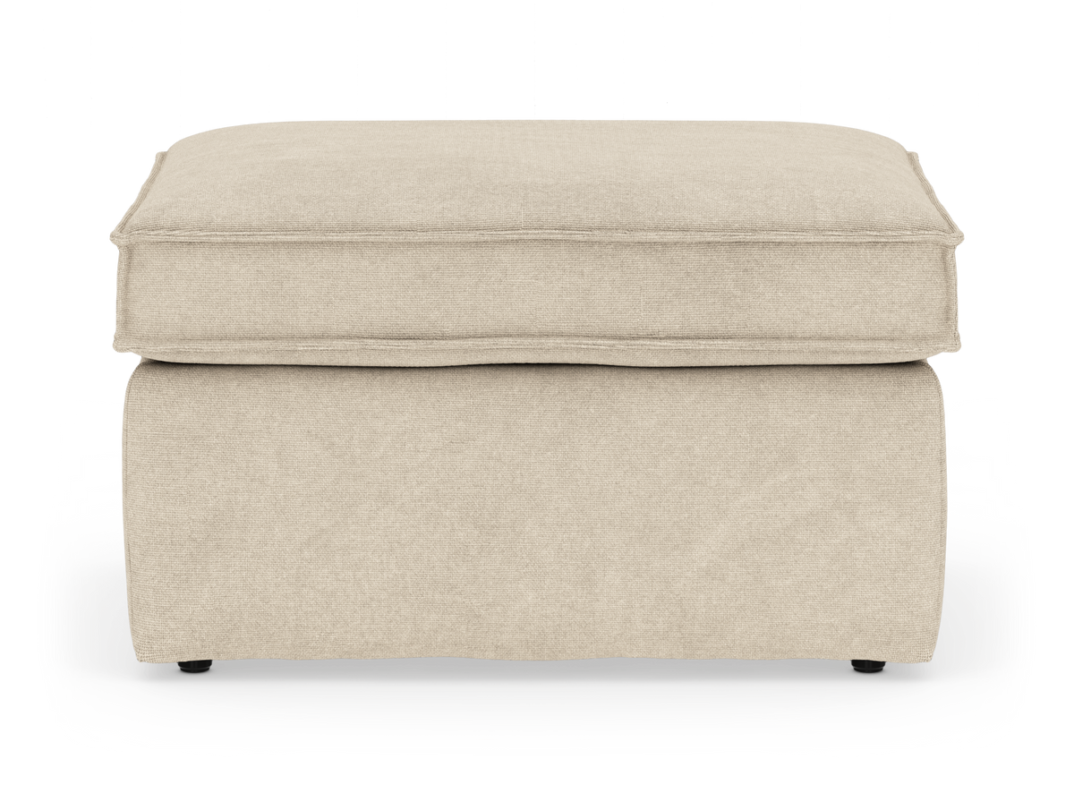 Beige stoppad ottoman/fotpall med mjuk kuddtopp, frilagd mot vit bakgrund.