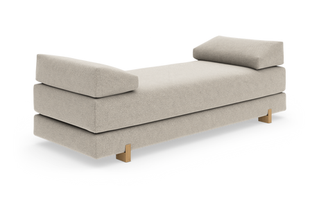Beige dagbädd med mjuka bolster i båda ändar och träben, frilagd mot vit bakgrund.