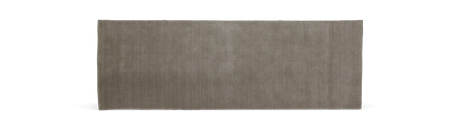 Modern, minimalist vardagsrum med soffa och kuddar i neutrala toner.