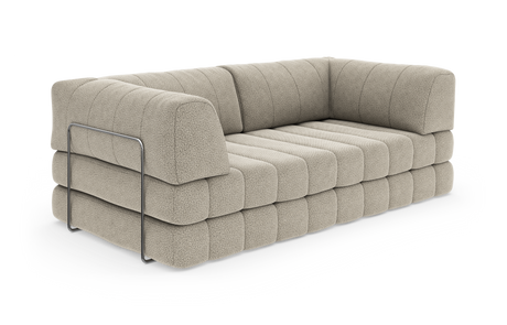 Beige modulsoffa med kanalquiltad sits och rygg, rundade kuddar och en kromad sidobygel, frilagd på vit bakgrund.