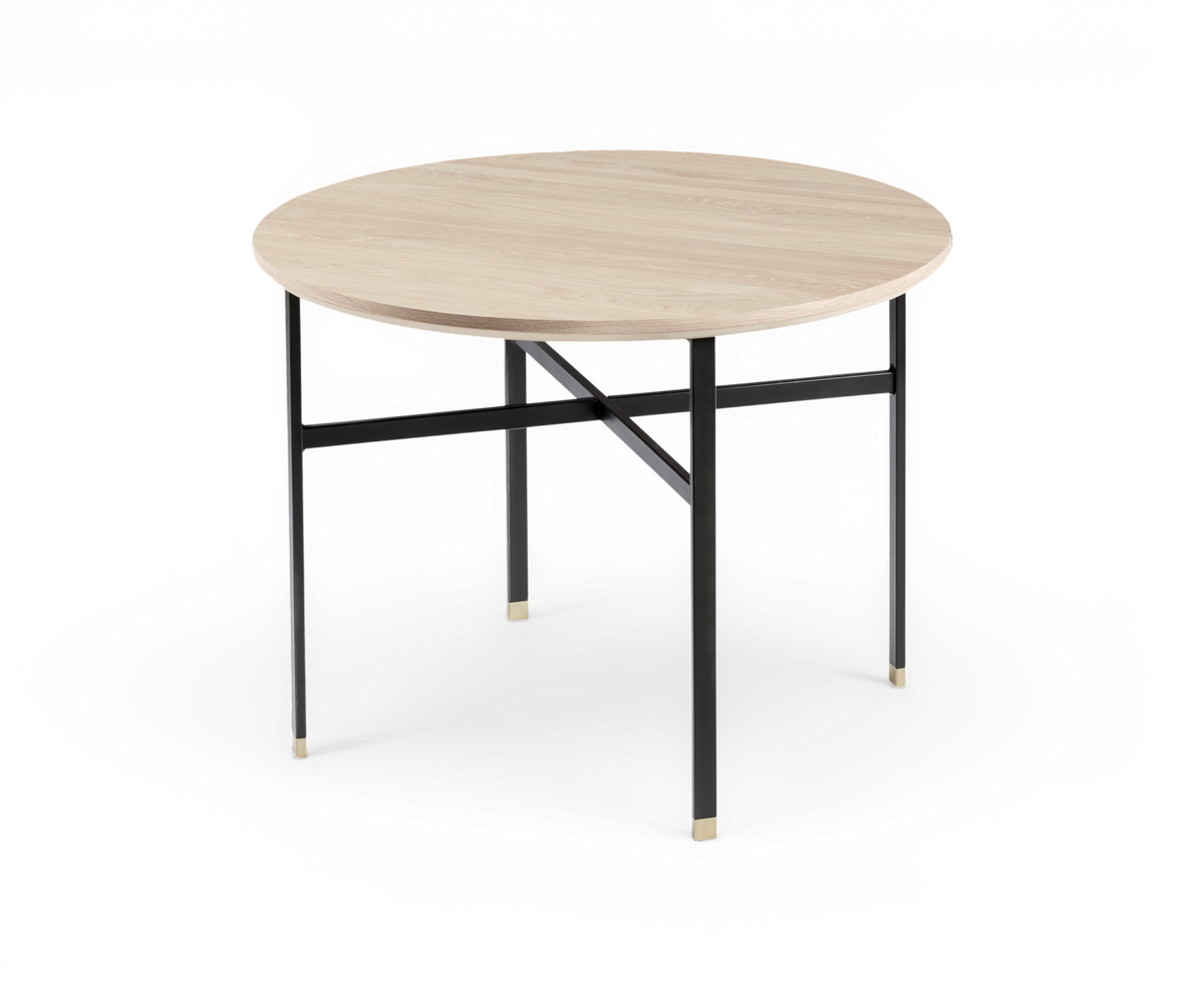 Runt matbord med ljus träskiva och svarta metallben med mässingsdetaljer.