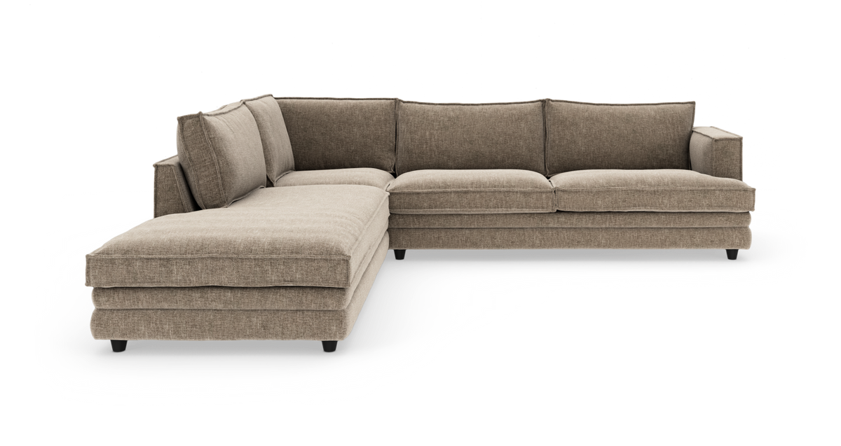 L-formad beige modulsoffa med schäslong på vänster sida, fotograferad i studio på vit bakgrund.