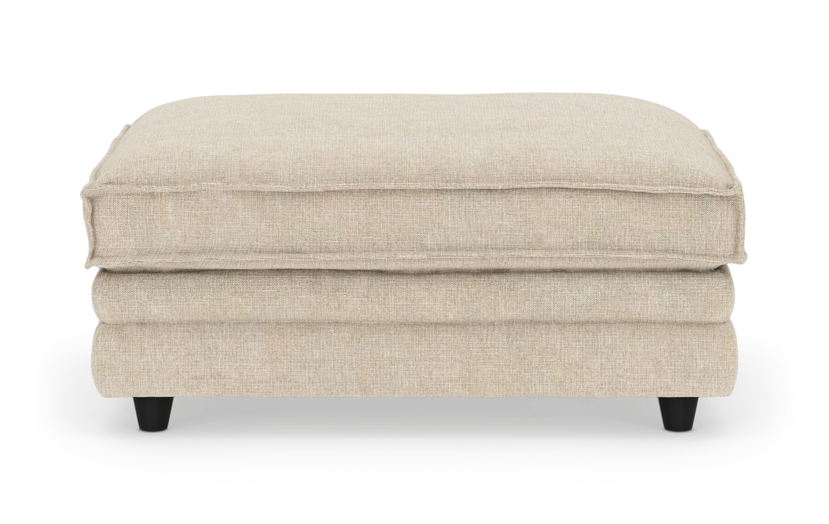 Beigefärgad rektangulär sittpuff/ottoman i tyg på svarta ben, frilagd på vit bakgrund.