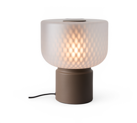 Bordslampa med frostat mönstrat glas och brun cylindrisk bas som lyser varmt.