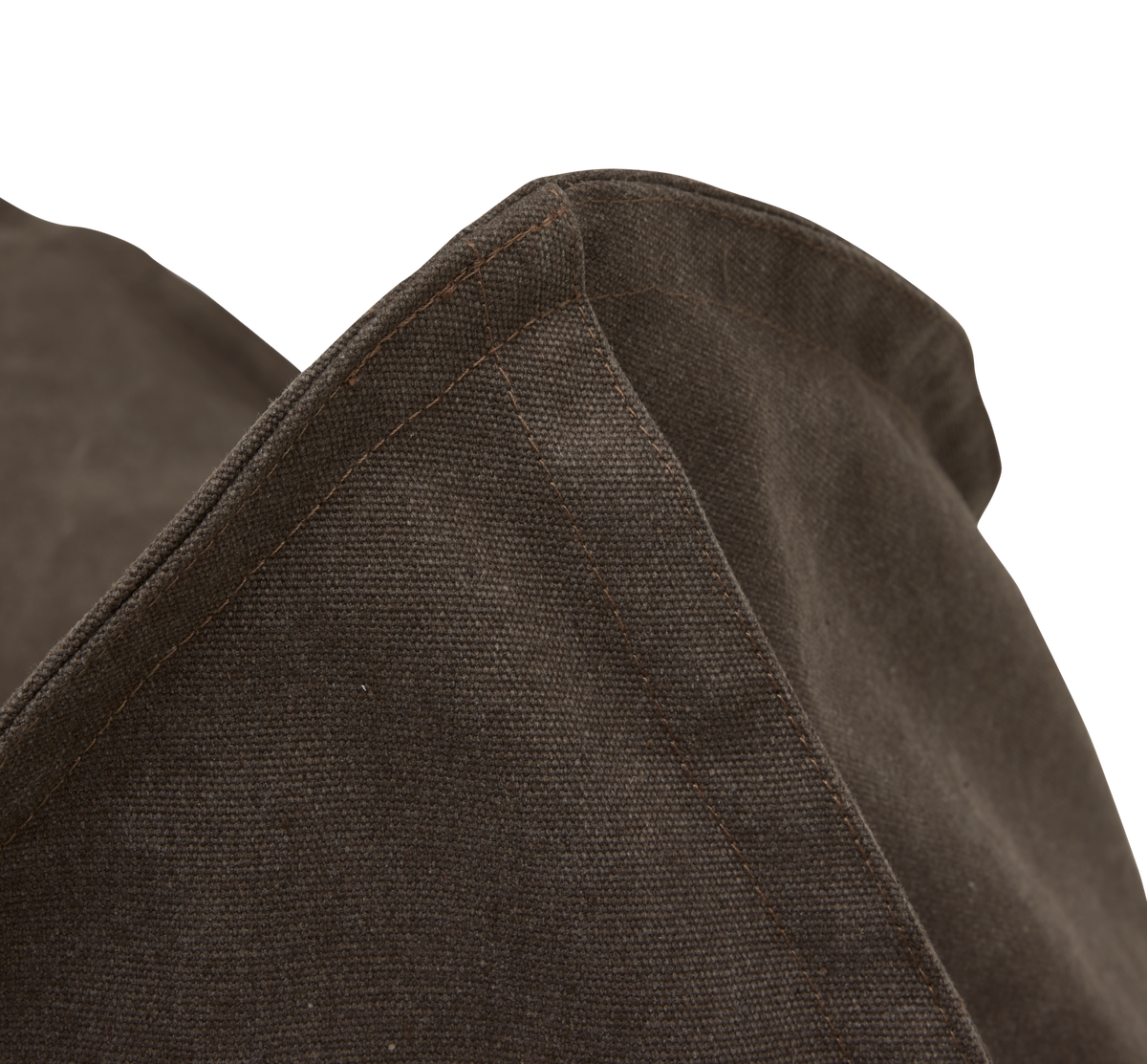 Närbild av mörkbrun textil med tydliga sömmar, troligen ett kuddfodral eller en sittpuff.