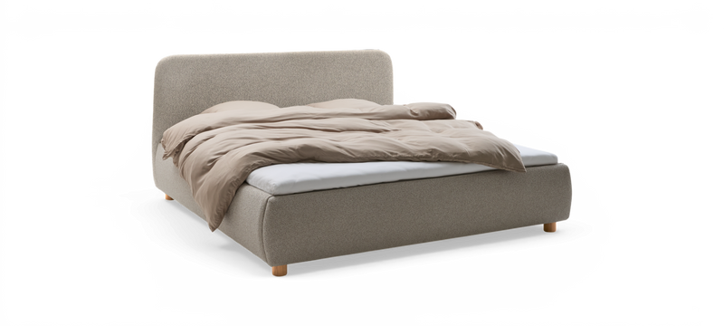 Stoppad dubbelsäng i ljusgrått tyg med beige täcke och runda träben, frilagd produktbild i sned vinkel._ps