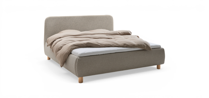 Polstrad säng med rundad huvudgavel i ljusgrå textil, beige täcke och ljusa träben._ps