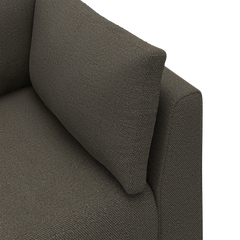 Närbild av ett mörkgrått soffhörn i grovt, texturerat tyg med en lös ryggkudde.