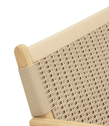 Närbild av beige vävd snorrygg på stol med ljus träram i diagonal vinkel.