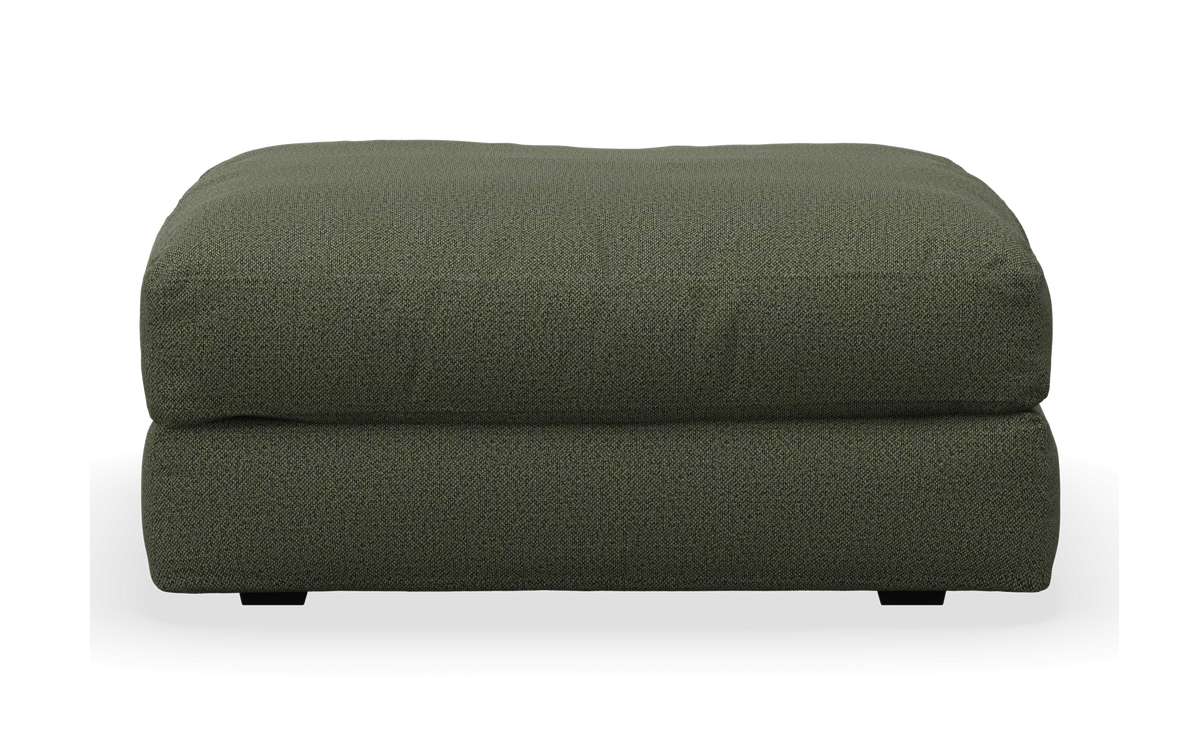 Grön tygpall/ottoman sedd framifrån.