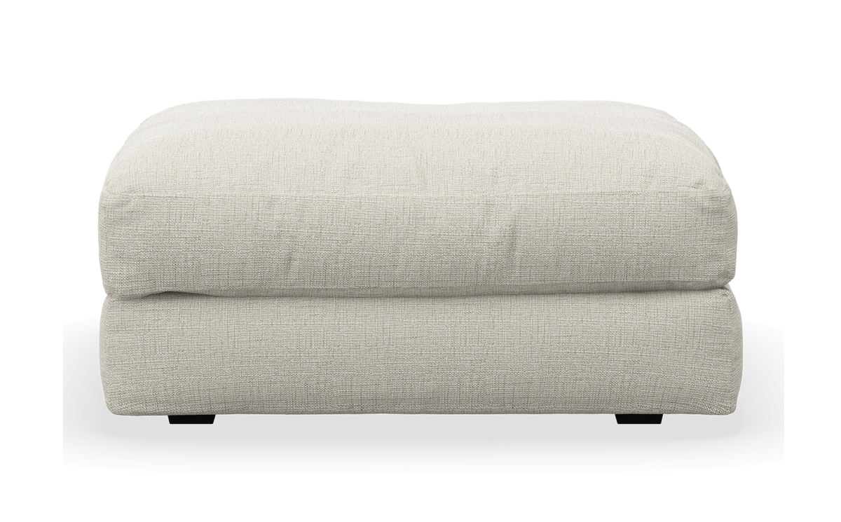 Ljusbeige textil-ottoman/puff i frontvy.