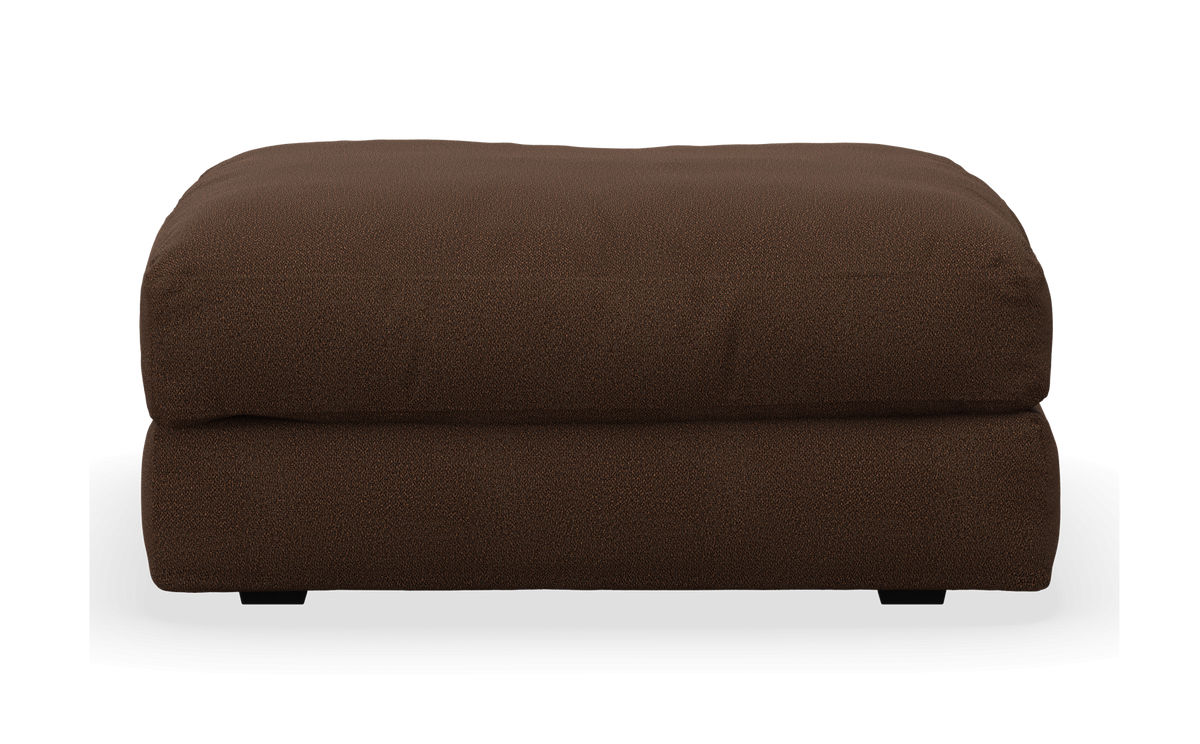 Brun, stoppad ottoman/puff i tyg, frilagd mot vit bakgrund, frontvy.