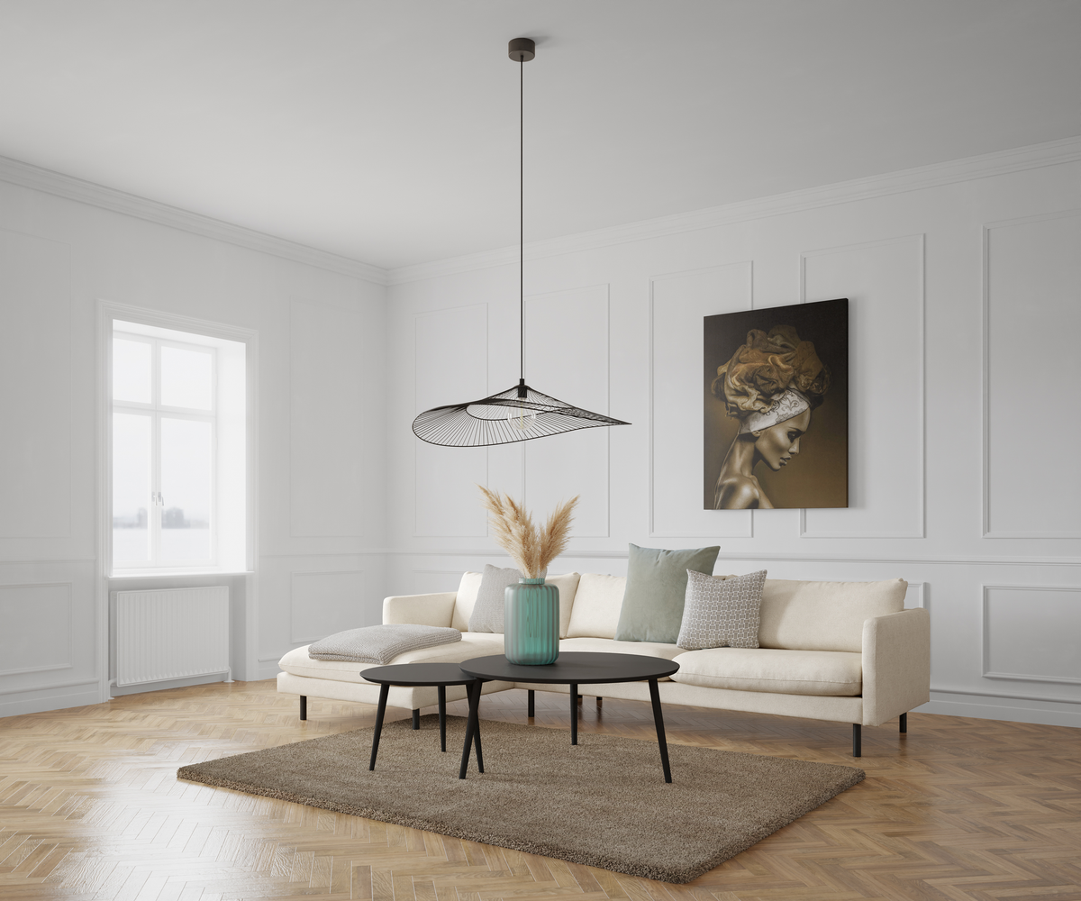 Ljust skandinaviskt vardagsrum med beige soffa, svarta satsbord, turkos vas med torkat pampasgräs, trådig pendellampa och väggkonst; fiskbensparkett och stort fönster i dagsljus.