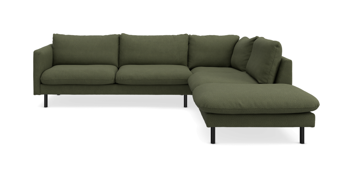 Grön hörnsoffa med schäslong till höger, modern design på smala svarta ben.