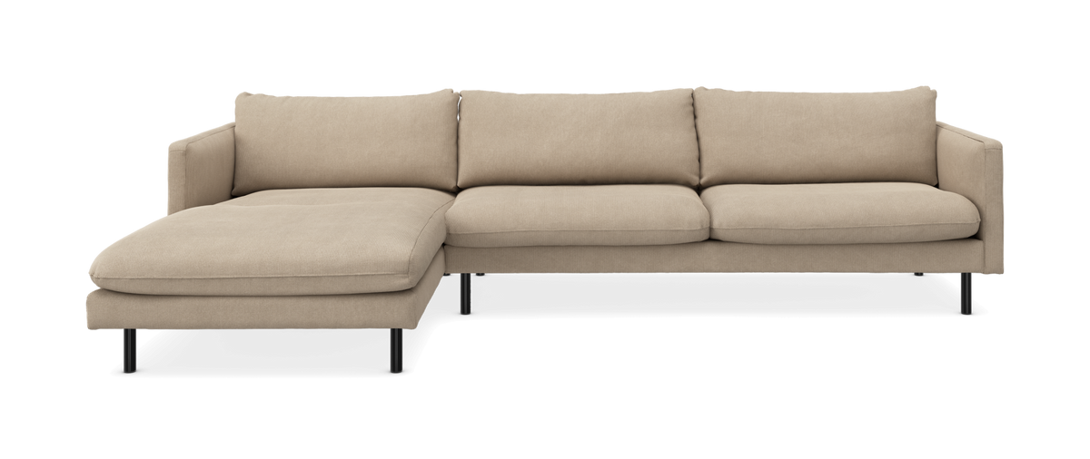 Beige hörnsoffa med schäslong till vänster på svarta ben, modern och minimalistisk, frilagd på vit bakgrund.