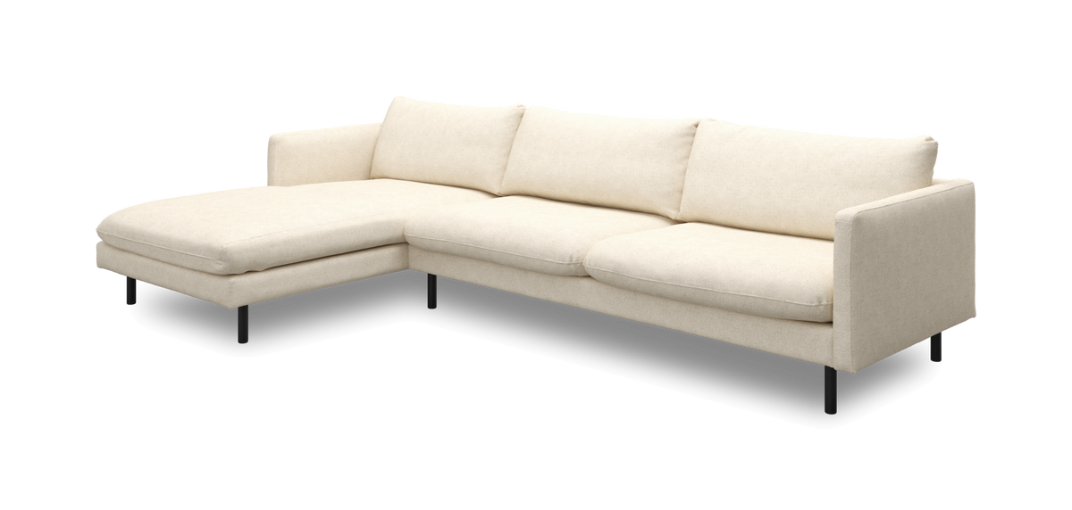 Beige hörnsoffa med vänstervänd schäslong och smala svarta ben.