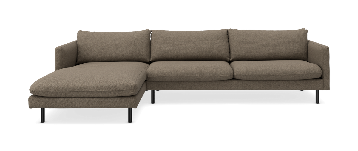Soffa med vänsterställd schäslong, tre sitsar, brun‑beige tyg och smala svarta ben.