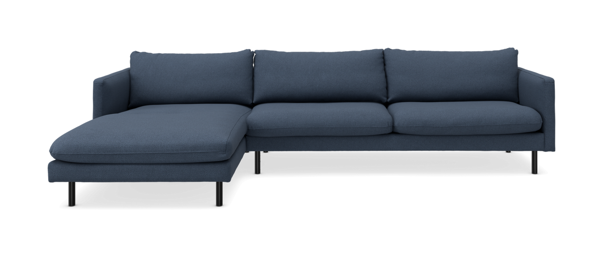 Blå vänstervänd chaiselongsoffa med tre sittdynor och smala svarta ben, studiofoto.