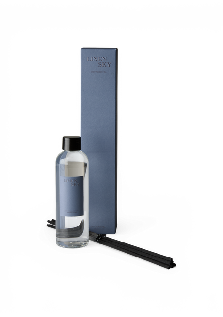 Linen Sky diffuser‑refill med flaska, blå ask och svarta doftpinnar.