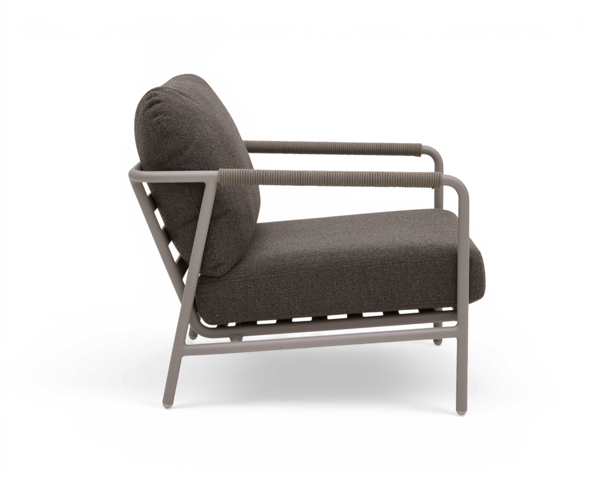 Sidovy av en modern grå loungestol med ljusgrå metallram och repomvikna armlän, frilagd mot vit bakgrund.