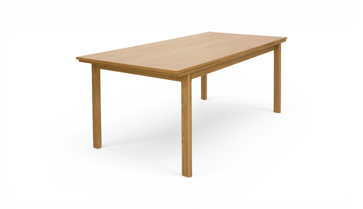 Rektangulärt matbord i ljus ek med fyra raka ben, fotat snett framifrån på vit bakgrund.