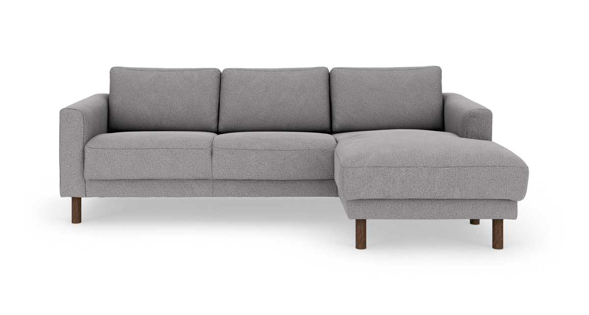 Grå 3‑sits soffa med högerställd schäslong och träben, frontvy.
