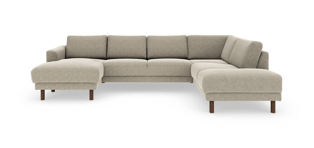 L‑formad beige modulsoffa med schäslong till vänster och runda träben, frilagd på vit bakgrund.