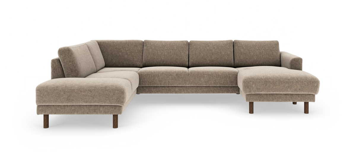 Beige modulsoffa i U‑form med schäslong till höger, runda träben och mjuka tygkuddar.