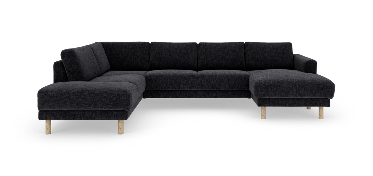Mörkgrå modulsoffa i U‑form med schäslonger på båda sidor och ljusa träben, frilagd på vit bakgrund.