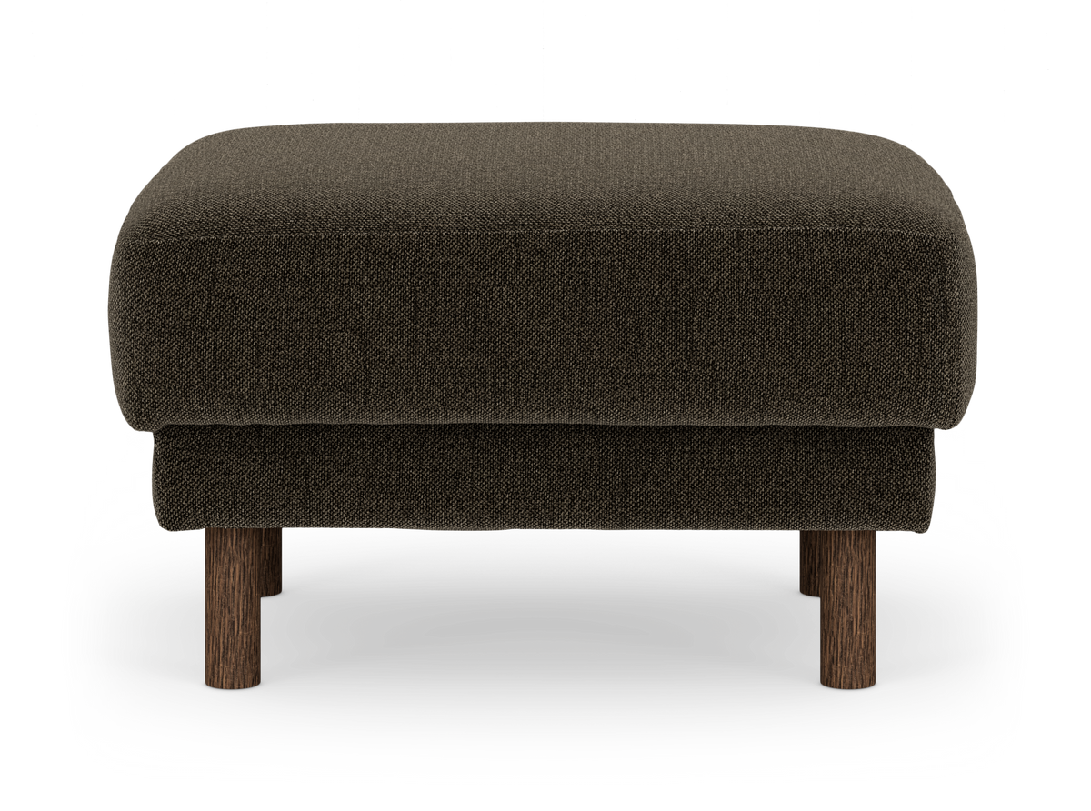 Mörkbrun tygpall/ottoman med rundade hörn och träben, frilagd på vit bakgrund.