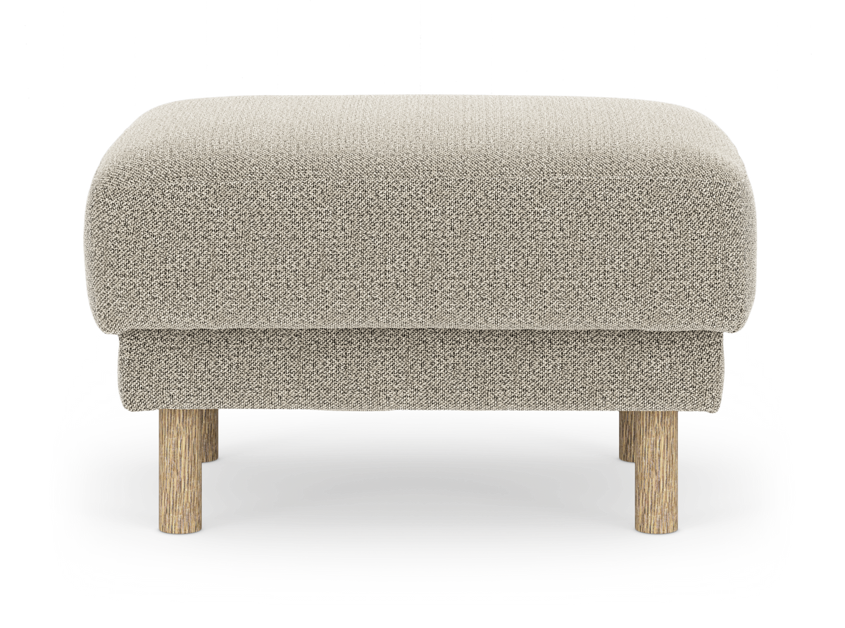 Beige fotpall i tyg med runda ben i ljust trä, frilagd framifrån.