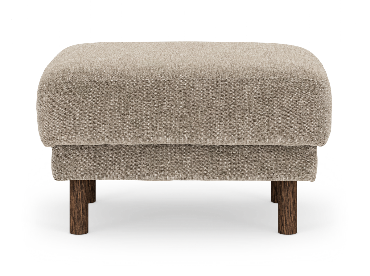 Beige fotpall i tyg med runda träben, frilagd på vit bakgrund.