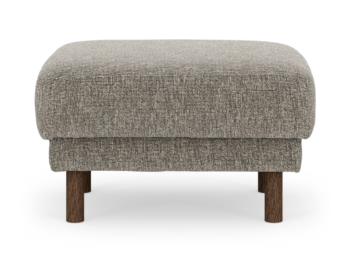 Beige fotpall i tyg med runda mörkbruna träben, frilagd mot vit bakgrund.