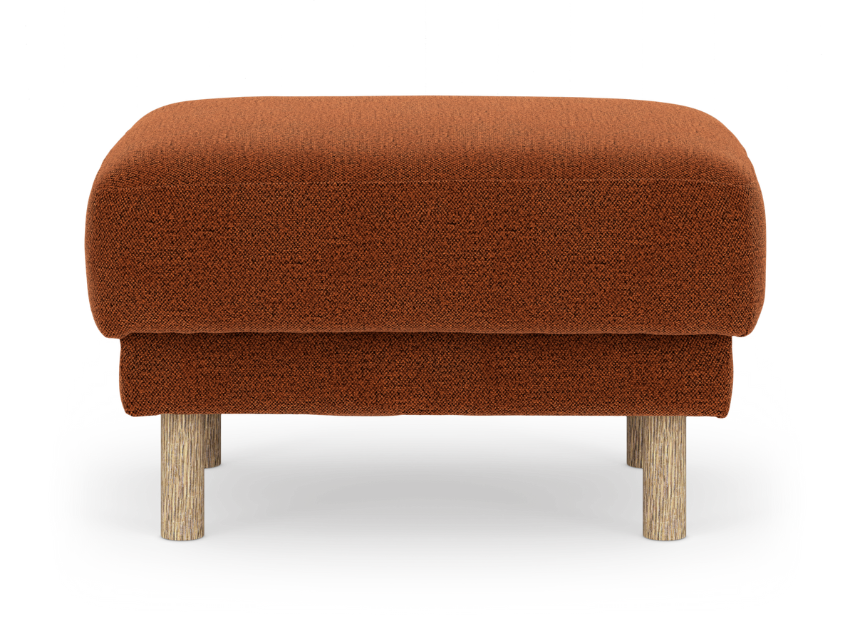 Rostorange tygklädd ottoman/puff med runda träben, sedd framifrån mot vit bakgrund.