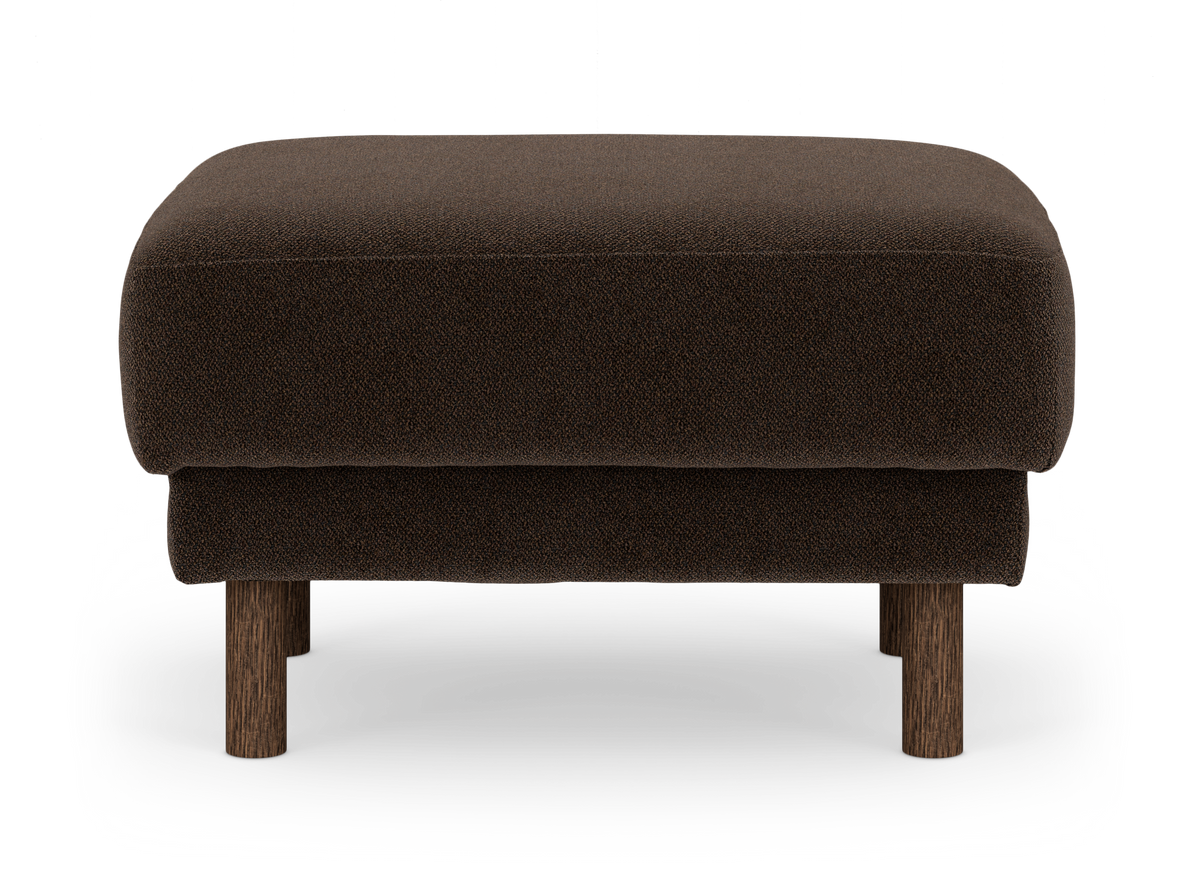 Mörkbrun ottoman/fotpall med tygklädsel och runda träben på vit bakgrund.
