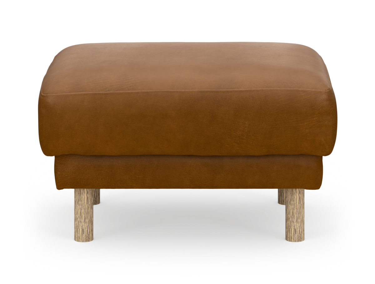 Brun ottoman/fotpall med runda träben, frilagd mot vit bakgrund.