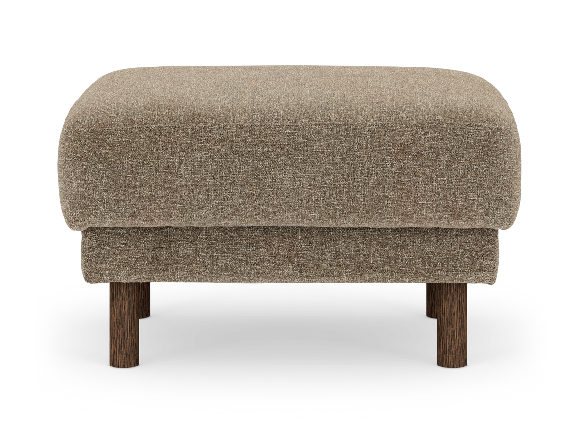 Brun, stoppad ottoman/fotpall i tyg med runda träben, frilagd på vit bakgrund.